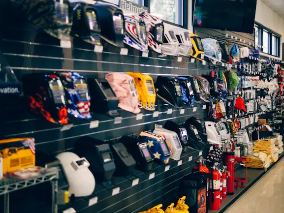 Welding helmets, PAPR systems, welding caps, and fire extinguishers on display at General Air's Littleton retail location.