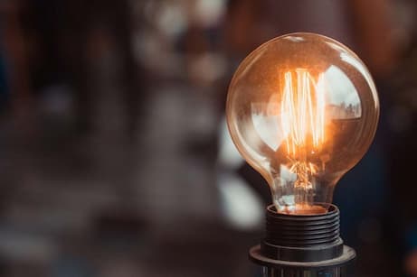 Argon light bulb glowing with a filament, inside a glass bulb filled with argon gas.