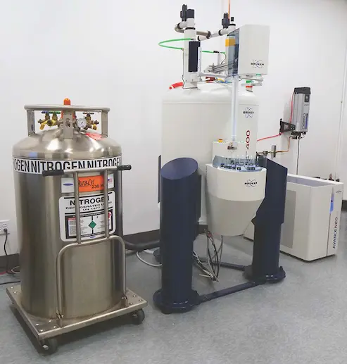 Liquid nitrogen dewar next to a Bruker NMR spectrometer in a laboratory setting